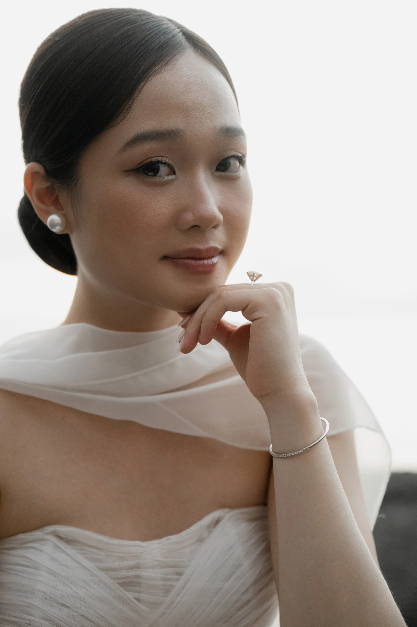 Linh nhìn vào máy ảnh với hoa tai ngọc trai.