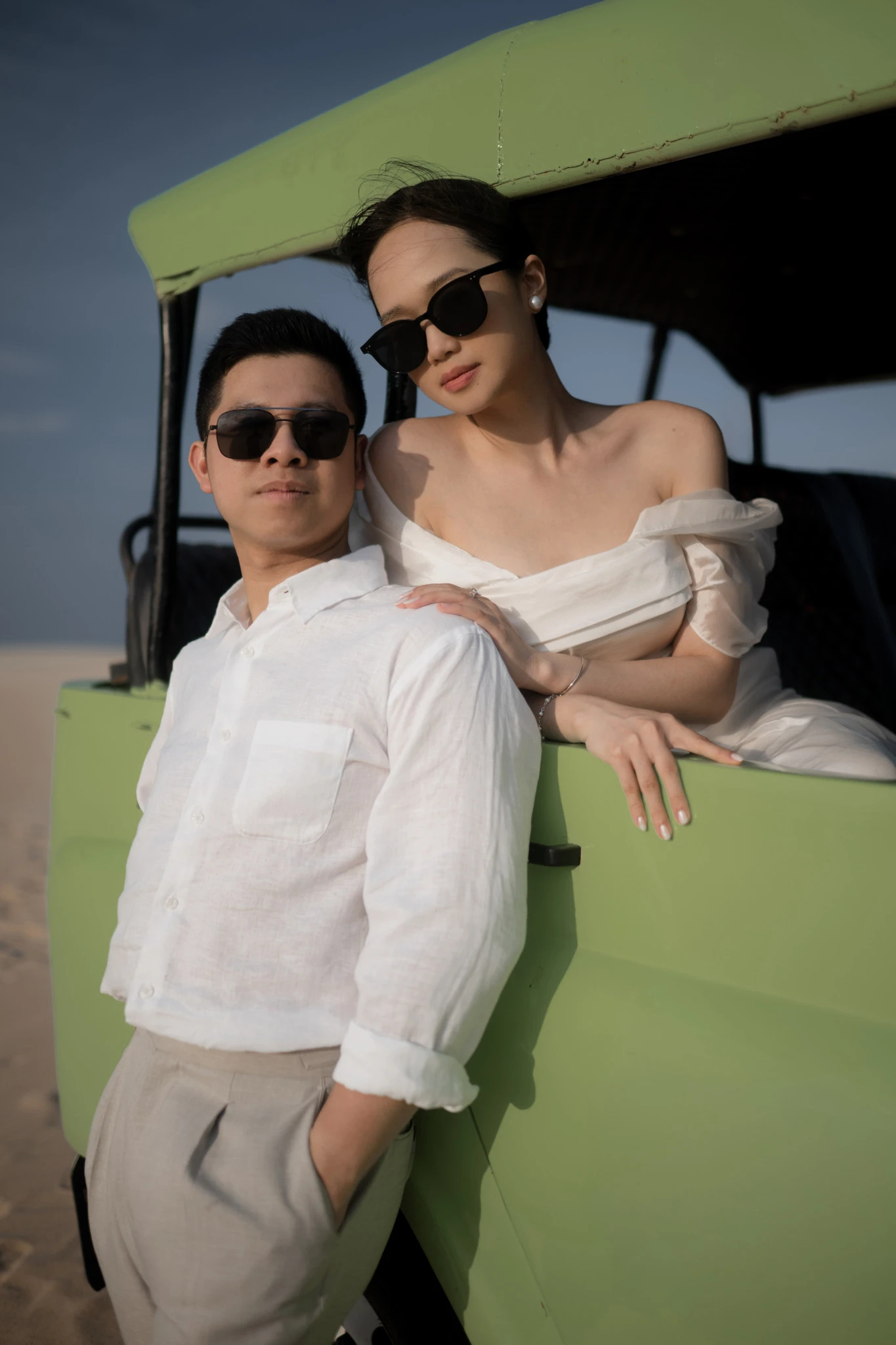 Linh và Bình đeo kính râm bên chiếc thuyền xanh.