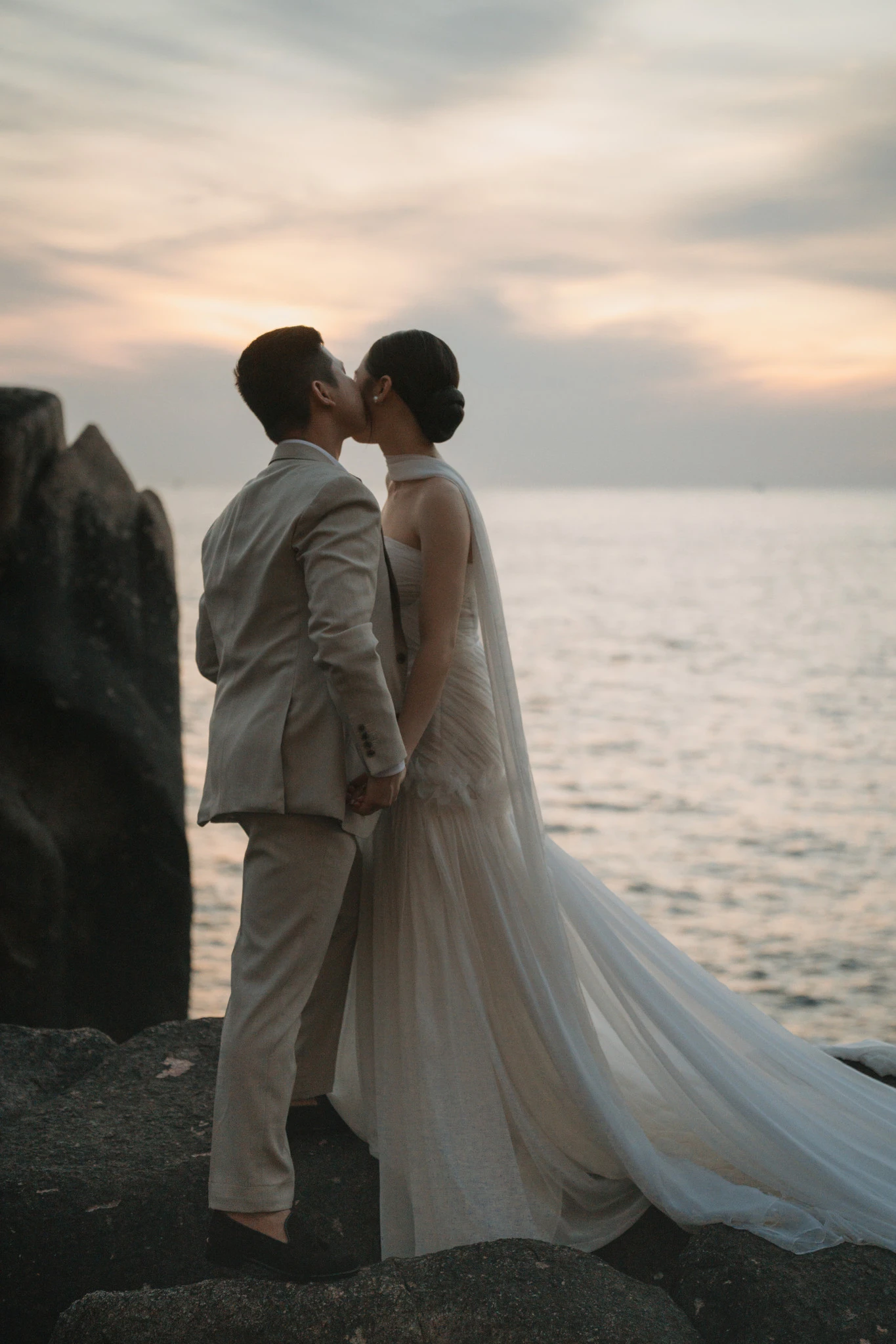 Linh và Bình hôn nhau trong ánh hoàng hôn bên biển.