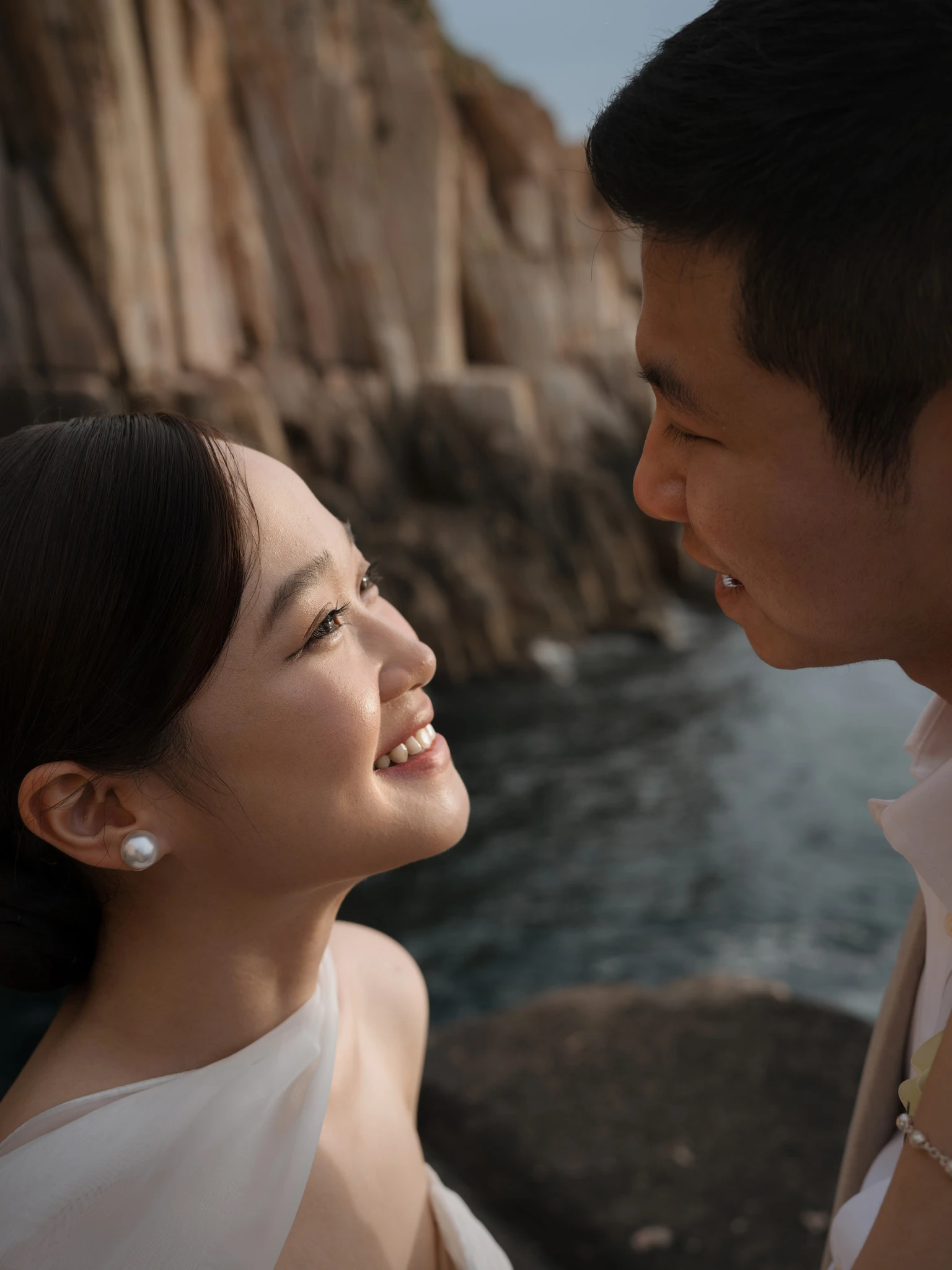 Linh mỉm cười nhìn Bình bên bờ đá.
